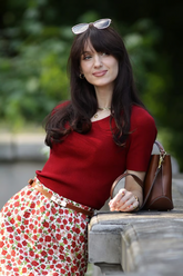 a lady in a ed sweater and a red floral printed skirt